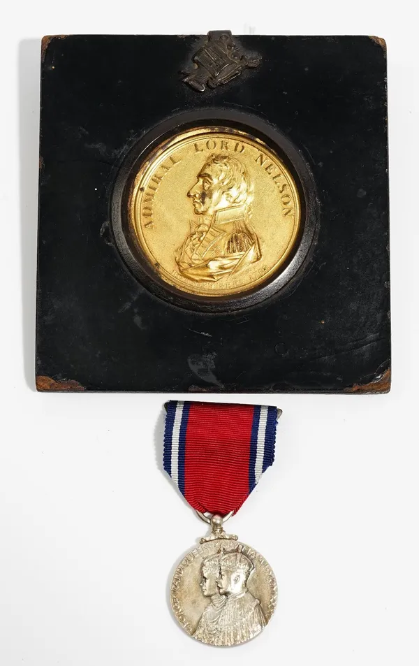 A gilt uniface medallion detailed Admiral Lord Nelson, displayed in an ebonised papier mache square frame and a George V 1935 Silver Jubilee medal wit