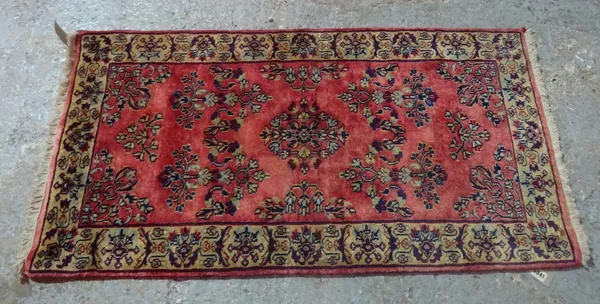 A Sarough rug, Persian, the madder field with sprays of floral design; a pale brown leaf and flower border, 122cm x 64cm.