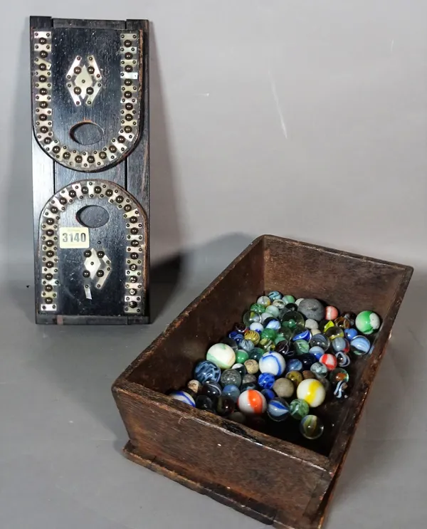 A group of 20th century glass marbles, an ebonised sliding book rack, 34cm, and a shallow wooden box, 31cm.