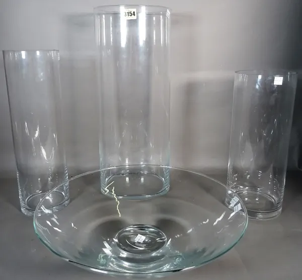 Glassware comprising; a modern group of three cylindrical glass vases, the largest 19cm diameter x 50cm high, a modern glass centre bowl, 40cm diamete