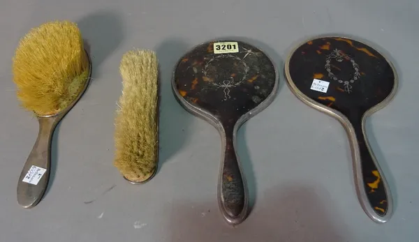 A late 19th century silver and tortoiseshell four piece dressing table set, comprising two mirrors and two brushes.