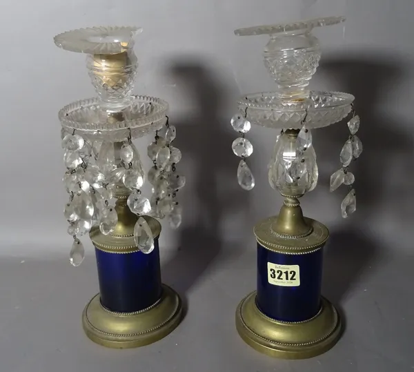 A pair of early 20th century brass and glass candlesticks, 32cm high, (2).