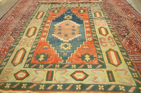 A Turkish carpet in polychrome colours, madder, indigo and pink central design, 277cm x 198cm.