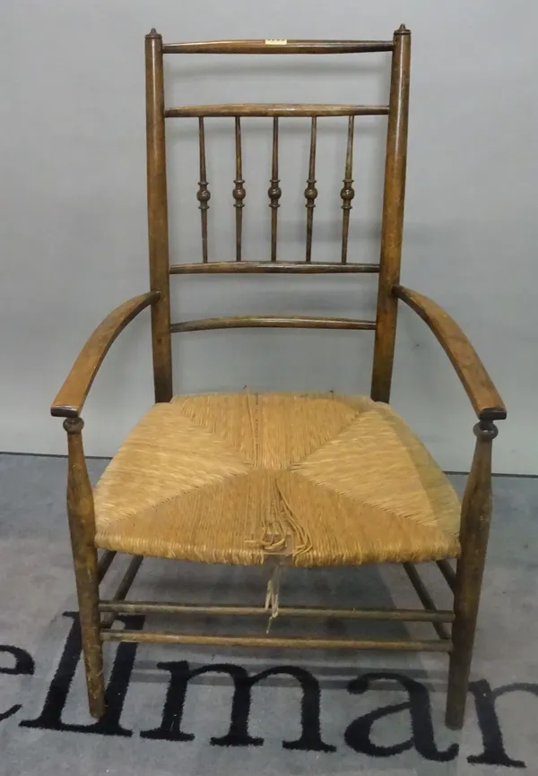 A 19th century stained beech low open armchair with rush seat, 53cm wide x 88cm high.