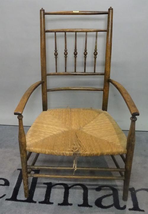 A 19th century stained beech low open armchair with rush seat, 53cm wide x 88cm high.