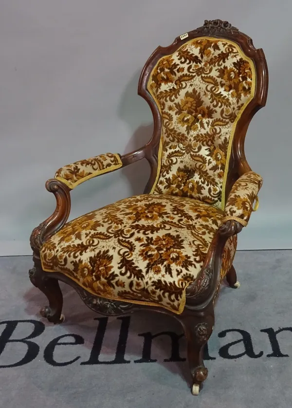 A Victorian mahogany low open armchair on cabriole supports, 74cm wide x 103cm high.