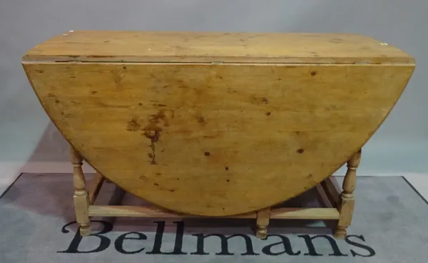 A early 20th century pine drop flap dining table, 136cm wide x 76cm.