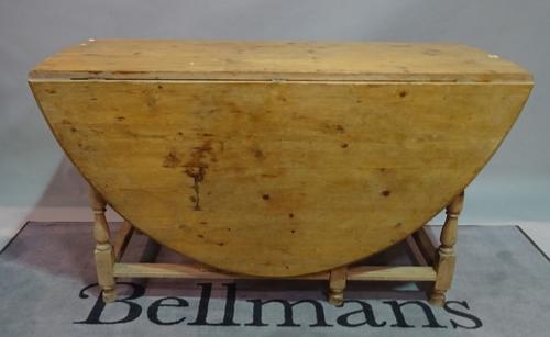 A early 20th century pine drop flap dining table, 136cm wide x 76cm.