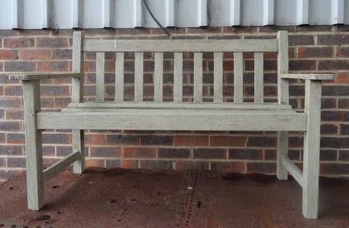 A green painted teak garden bench, with slatted back and seat, 128cm wide x 82cm high.