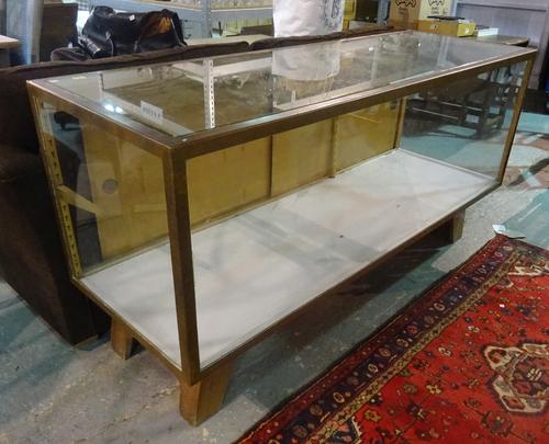 A mid-20th century bronze framed rectangular show case, on splayed block feet, 179cm wide x 90cm high.