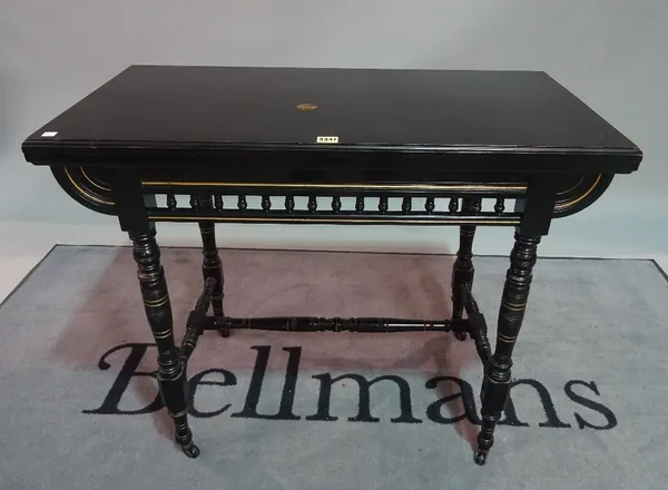 A Victorian ebonised Aesthetic foldover card table, on ring turned supports, 91cm wide x 74cm high.