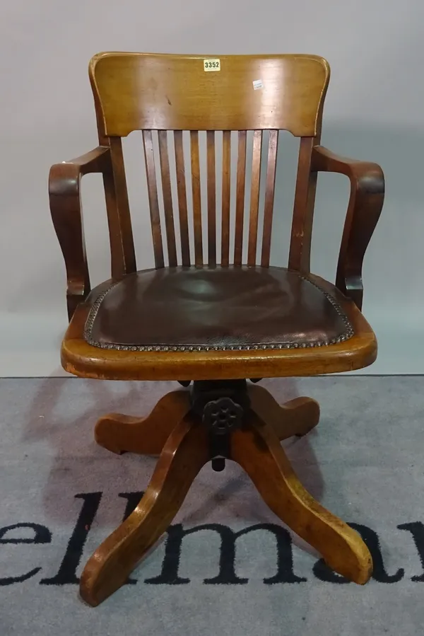 An early 20th century stained beech swivel office open armchair, 53cm wide x 83cm high.