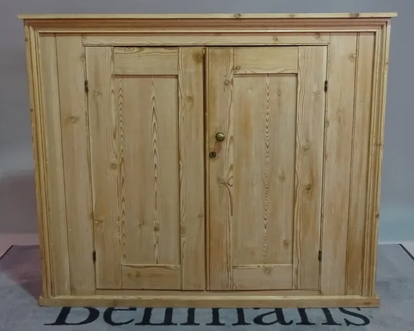 An early 20th century pine side cabinet, the moulded panel doors on plinth base, 137cm wide x 117cm high.