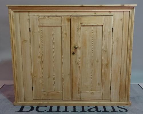 An early 20th century pine side cabinet, the moulded panel doors on plinth base, 137cm wide x 117cm high.