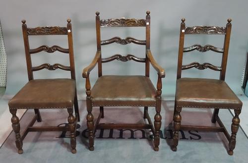 A set of three Charles II style oak ladder back dining chairs, to include a carver, together with two 19th century carved oak chairs, (5).