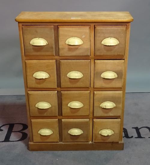 A modern beech bank of three rows of four drawers on plinth base, 64cm wide x 88cm high.