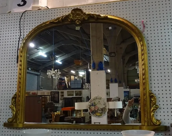 A Victorian style gold painted arch top overmantel wall mirror, 130cm wide x 94cm high, and a modern gilt metal oval wall mirror, 40cm wide x 60cm hig