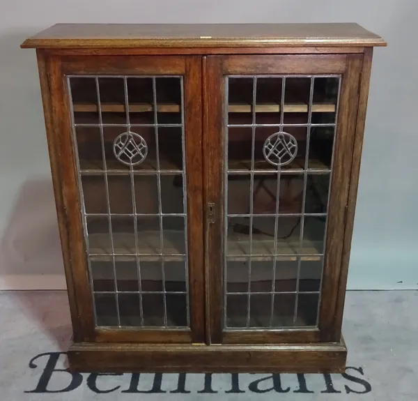 An early 20th century oak glazed two door side cabinet on plinth base, 104cm wide x 120cm high.