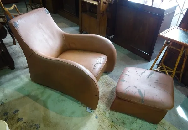 After Matthew Hilton, a mid-20th century leather low armchair, 68cm wide x 85cm high, and a matching footstool, 50cm wide x 33cm high.