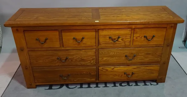 A modern oak side chest, of four short and four long drawers, 160cm wide x 76cm high.