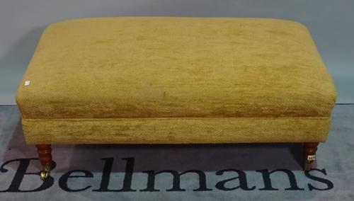 A reproduction Victorian style centre stool, with stuff-over rectangular seat, on turned mahogany legs and castors, 112cm wide.