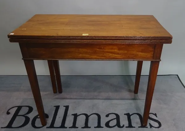 A George III mahogany foldover tea table on tapering square supports, 91cm x 78cm high.