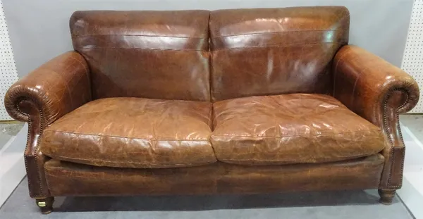 A 20th century brown leather upholstered sofa, with roll over arms on turned supports, 198cm wide x 98cm high.