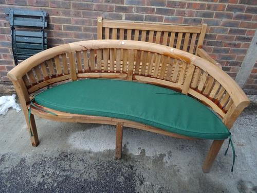 A modern hardwood garden bench with curved back, 160cm wide x 85cm high.