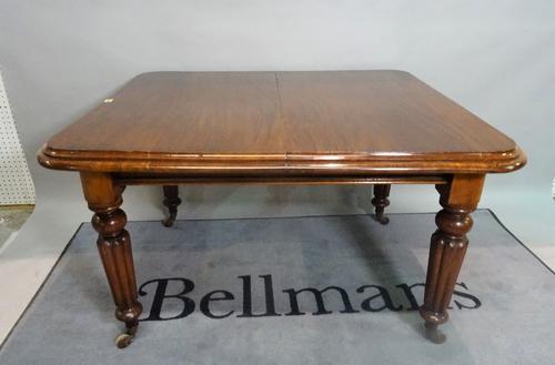 A Victorian mahogany extending dining table, on reeded tapering supports, with one extra leaf, 122cm wide x 74cm high x 164cm fully extended.