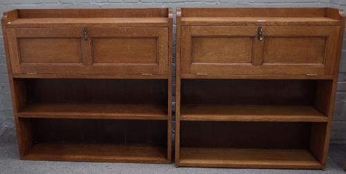 A near pair of oak Arts & Crafts floor standing bookcases, with 3/4 galleried top over fall front and two open shelves, 107cm wide x 105cm high and...