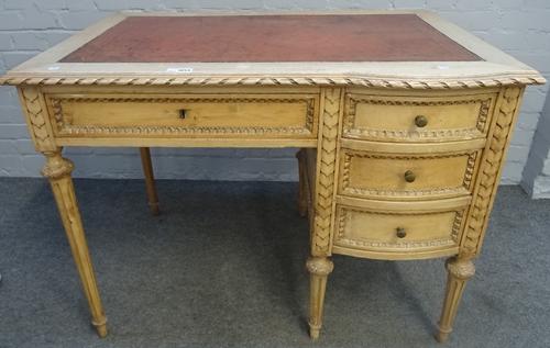An early 20th century carved and painted beech writing desk of Louis XVI design with four frieze drawers, on tapering fluted supports, 106cm wide x...