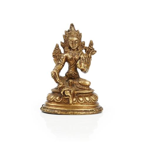A small Tibetan bronze figure of Green Tara, seated in traditional pose with right foot resting on a lotus flower, 8cm. high.