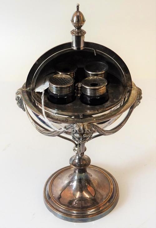 A silver plated on copper ink stand, of sprung spherical form, opening to reveal four silver plated metal mounted blue glass bottles, the stand...