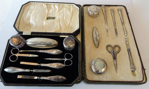 A German manicure set, the eight fittings, including two lidded glass toilet jars, a nail buffer, a pair of scissors and four implements, detailed...
