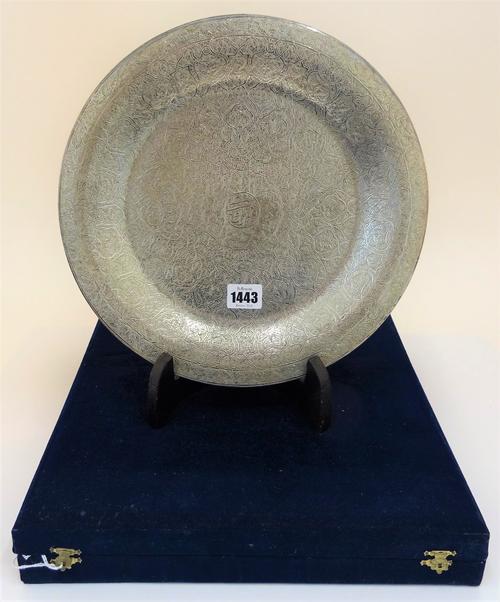 An Egyptian circular dish, with profusely engraved decoration and Arabic script to the centre, diameter 31cm, weight 680 gms, with a folding black...