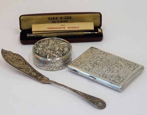 A circular box and cover, decorated with a tavern scene, probably European, a Victorian silver rectangular case with engraved decoration, Birmingham...