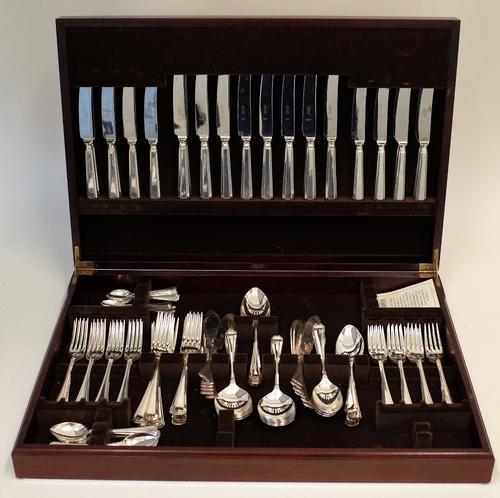 A silver plated canteen of table flatware, comprising; twelve steel bladed table knives, twelve steel bladed cheese knives, four table spoons, twelve...