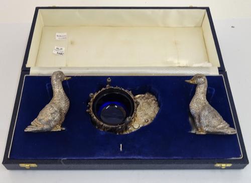 A silver modern three piece condiment set, comprising; a salt and a pepperette, modelled as ducks and a mustard modelled as a well, decorated with...