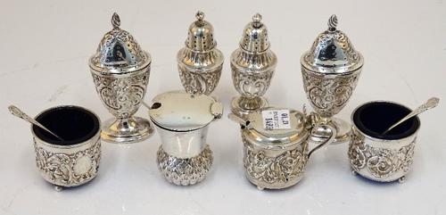 A group of silver condiments comprising; a Scottish mustard pot, designed as a thistle, Edinburgh 1922, a pair of urn shaped pepperettes of oval...