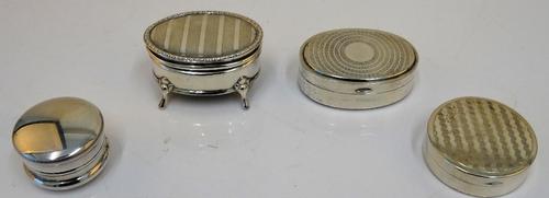 A silver oval hinge lidded box, gilt within, the lid engine turned, Birmingham 1918, a silver oval hinge lidded small trinket box, raised on four...