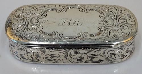 A Victorian silver hinge lidded snuff box, the cover initial engraved within a shaped oval cartouche, otherwise with floral and feathered scroll...