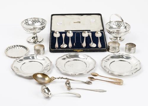 Silver, comprising; a bonbon basket with pierced decoration and with a swingover handle, Birmingham 1910, a pedestal bonbon basket, a pair of napkin...