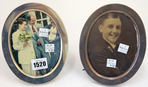 A pair of silver mounted oval strut backed photograph frames, each monogram engraved at the top, London 1901.