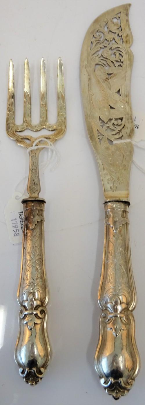 A pair of Victorian silver fish servers, with pierced and engraved decoration and having loaded handles, Sheffield 1849.