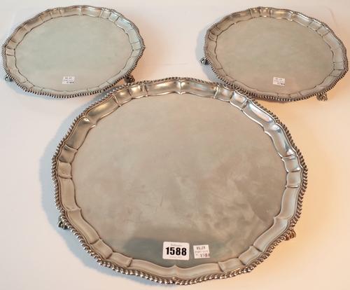 A set of three silver salvers, comprising; one larger salver, diameter 33.5cm, Sheffield 1927 and a pair of smaller salvers, diameter 24.5cm,...