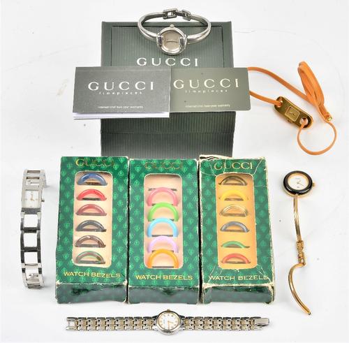 A lady's Gucci steel bangle wristwatch, with a warranty card and a booklet, with a Gucci case, another lady's Gucci bangle wristwatch, three boxes...