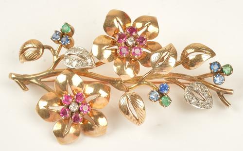 A gold, diamond, ruby, sapphire and emerald brooch, designed as a floral and foliate spray, mounted with circular cut gemstones, length 6cm, gross...