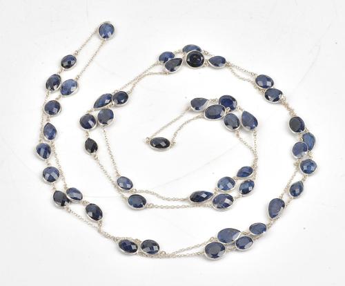 A silver and sapphire long chain, the oval link chain spectacle set with variously cut sapphires, length 165cm, gross weight 60 gms.