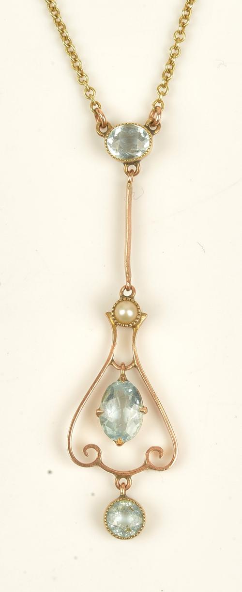 A gold, aquamarine and seed pearl set pendant, in a drop shaped openwork design, with a gold trace link neckchain, on a cylindrical clasp, detailed 9...