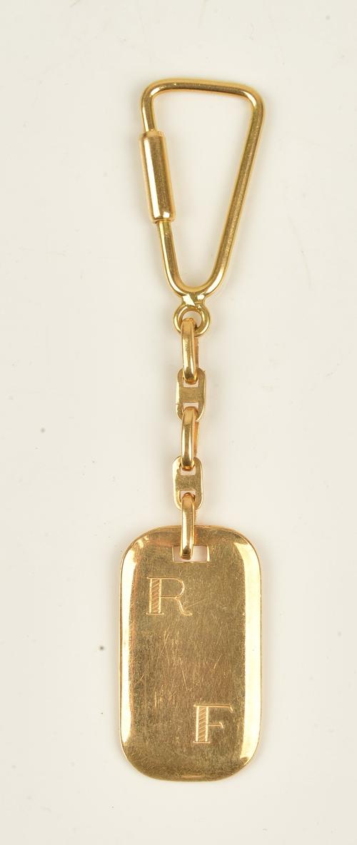 A gold key ring with a curved rectangular initial engraved panel and with a screw top fitting, detailed 750, gross weight 15.4gms.
